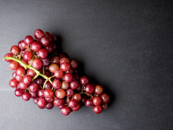 Vista superior de las uvas rojas sobre fondo negro. Espacio libre para texto — Foto de Stock