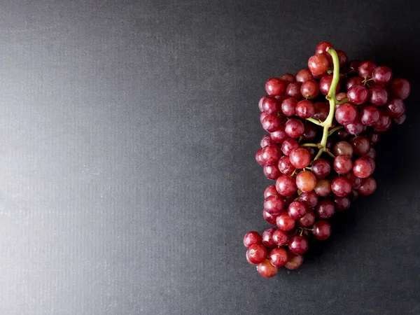 Vista superior de las uvas rojas sobre fondo negro. Espacio libre para texto — Foto de Stock