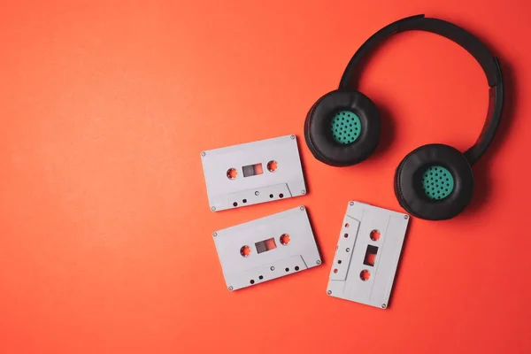 Headphones modernos com cassetes de áudio em fundo laranja. Espaço livre para texto — Fotografia de Stock
