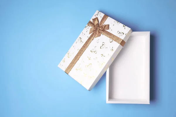 Вид зверху на відкриту білу подарункову коробку на синьому фоні. Вільний простір для тексту — стокове фото