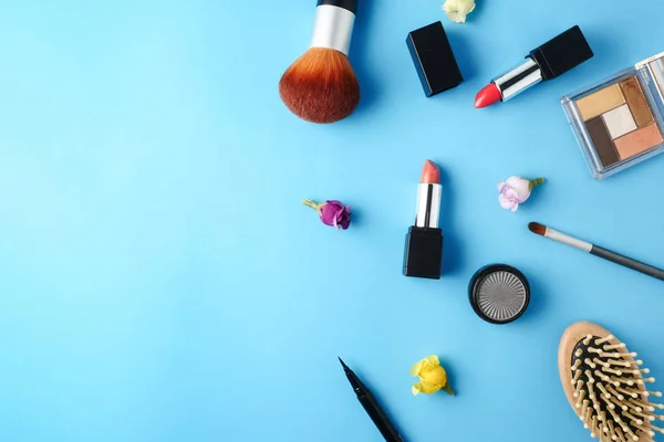 Ovanifrån av kosmetika som angetts för makeup på en blå bakgrund. Ledigt utrymme för text. — Stockfoto