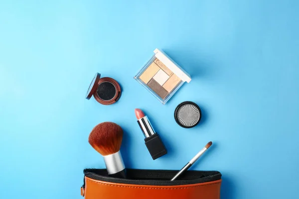 Bovenaanzicht van cosmetica voor make-up op een blauwe achtergrond instellen. — Stockfoto