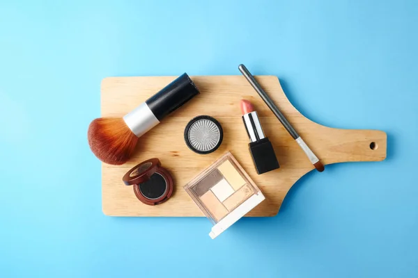 Bovenaanzicht van cosmetica instellen voor make-up op een blauwe achtergrond. Vrije ruimte voor tekst. — Stockfoto