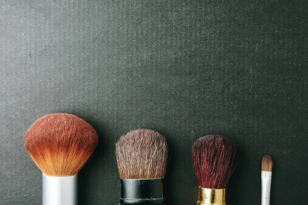 Makeup borstar på svart bakgrund, med utrymme för text. — Stockfoto