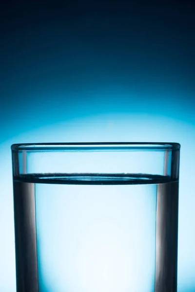 A glass of water on blue background. — Stock Photo, Image