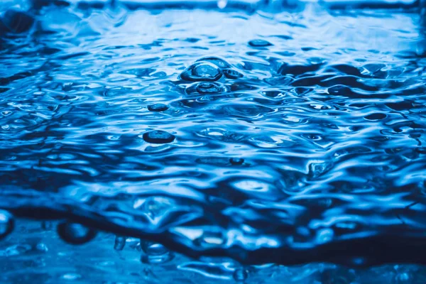 Blaue Welle und Blasen auf der Wasseroberfläche Hintergrund. — Stockfoto