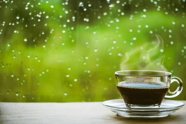 Cup of coffee on the table inside the window, coffee break in the morning with rainy day, relaxing and refreshing concepts. — Stock Photo, Image