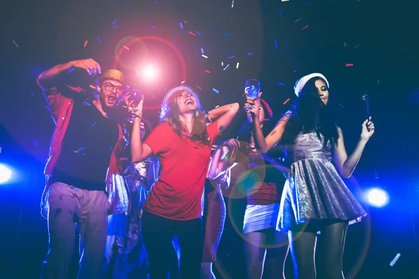 Fiesta de año nuevo, vacaciones, celebración, vida nocturna y el concepto de la gente - Los jóvenes se divierten bailando en una fiesta . — Foto de Stock