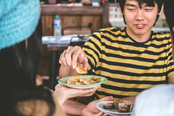 Aziatische jongeman eten snack met zijn vrienden thuis. — Stockfoto