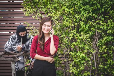 Hırsız elinde bir bıçak ve tek başına yürüyor, Asyalı kadın, seyir ve bekleyen çantasını çalmak.