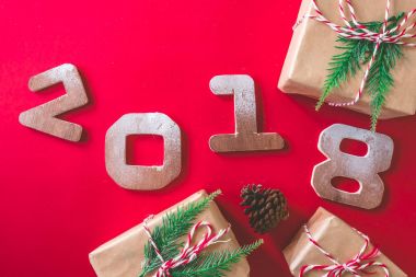 Ahşap sayılarla 2018 hediye kutuları ve Noel dekorasyonu kırmızı zemin üzerine. Mutlu yeni yıl kavramı