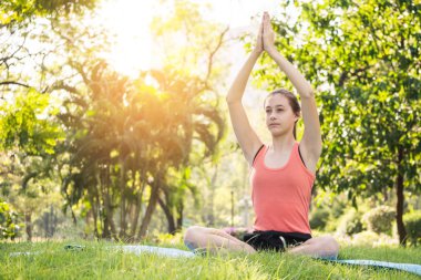 Güzel kadın parkta yoga egzersizleri yapıyor. Sağlıklı yaşam kavramı.