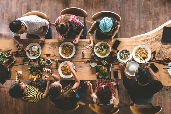 Bir grup mutlu arkadaş güzel yiyecekler ve içecekler yiyip içip eğleniyorlar, aile manzarası akşam yemeği yemek için evde toplanıyor..