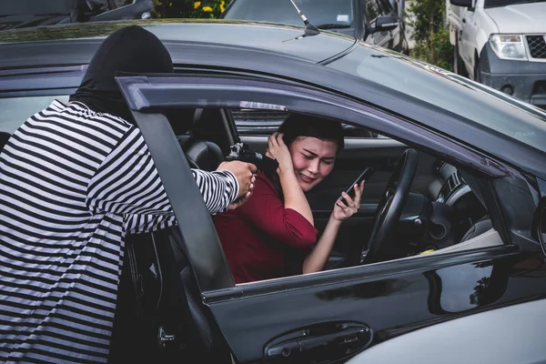 Rover wijzen een pistool te schrikken van de jonge vrouw te beroven van haar auto. — Stockfoto