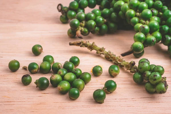 Peppercorns verde sobre fondo de madera . —  Fotos de Stock