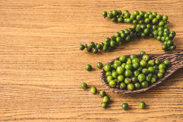 Ahşap zemin üzerine yeşil peppercorns. Metin için boş alan — Stok fotoğraf