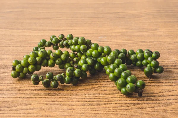 Peppercorns verde sobre fondo de madera . —  Fotos de Stock