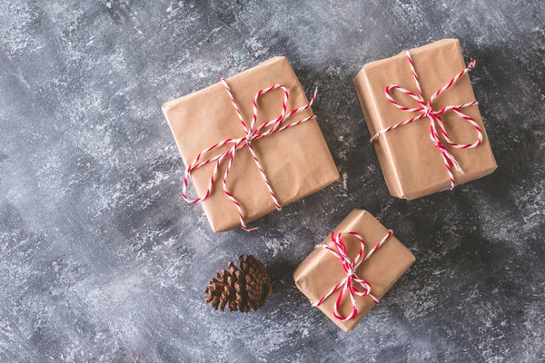 Top view of Gift packages wrapped in brown paper on gray grunge background.
