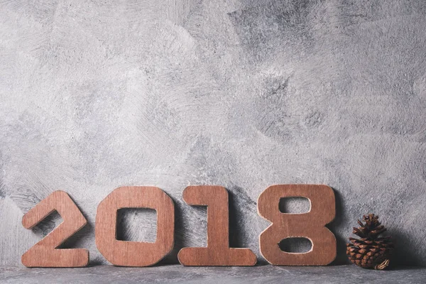Números de madera 2018 sobre fondo grunge gris. Feliz Año Nuevo concepto. Espacio libre para texto — Foto de Stock