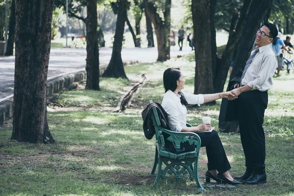 Happy Asijské obchodní muž a žena mluvila ve veřejném parku po dokončení práce. — Stock fotografie