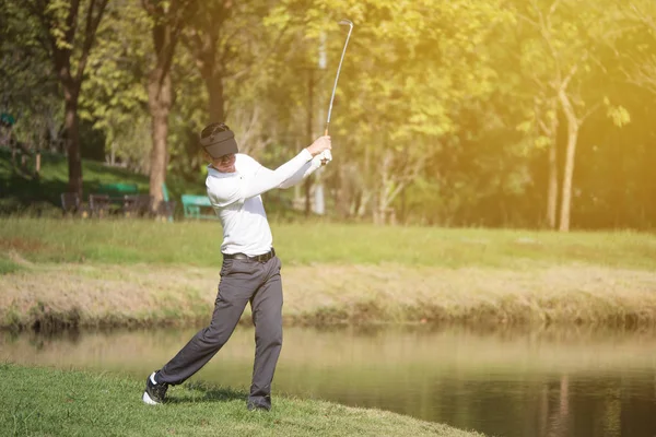 Homem asiático jogador de golfe balançando motorista de golfe clube no campo de golfe . — Fotografia de Stock