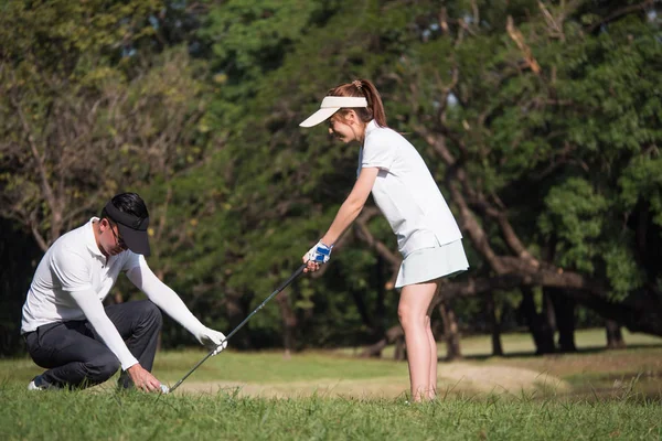 Asiático jovem casal jogar golfe no campo de golfe, o parceiro masculino é treinador para o golfista feminino — Fotografia de Stock