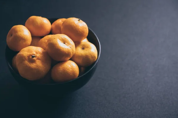 Свіжі мандарини в мисці, апельсинові фрукти на темному фоні . — стокове фото