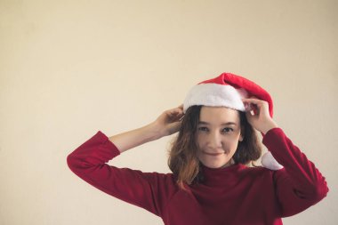 Mutlu Asyalı kadın portresi kırmızı Noel şapka ve kırmızı kazağı giymiş.