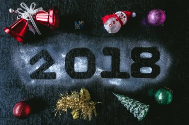Numaraları ile Noel süslemeleri siyah bir zemin üzerine beyaz kar üzerinde yazılı 2018. Mutlu yeni yıl kavramı