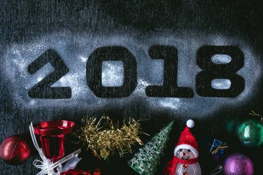 Numaraları ile Noel süslemeleri siyah bir zemin üzerine beyaz kar üzerinde yazılı 2018. Mutlu yeni yıl kavramı