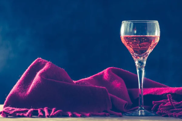 Copa de vino con bufanda roja en la mesa, fondo negro — Foto de Stock