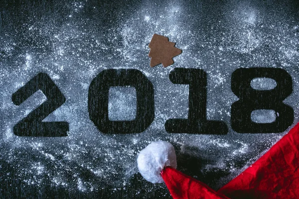 Los números 2018 escritos en la nieve blanca con sombrero de Santa — Foto de Stock