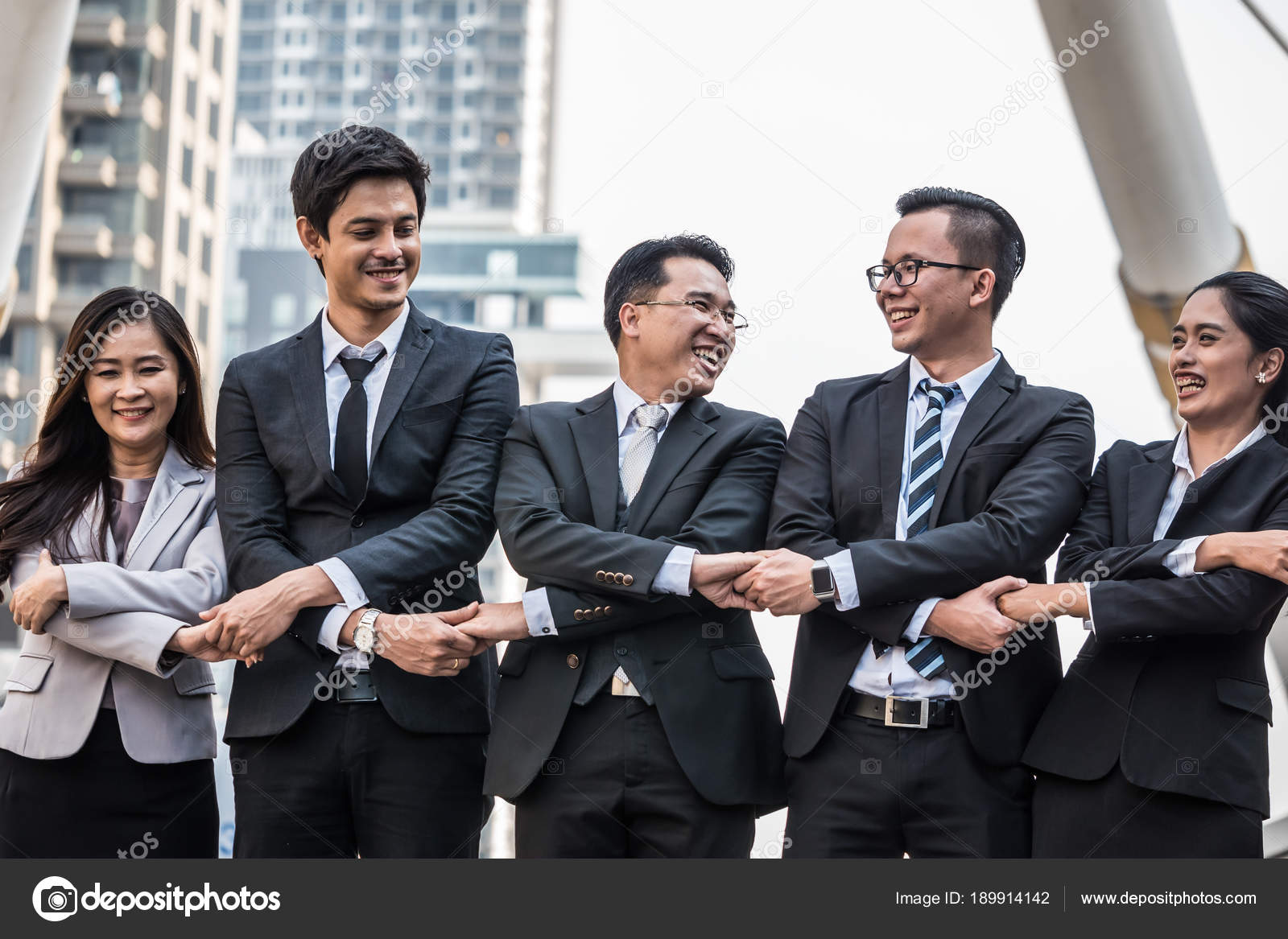 Successful Asian business team celebrating their triumph with holding
