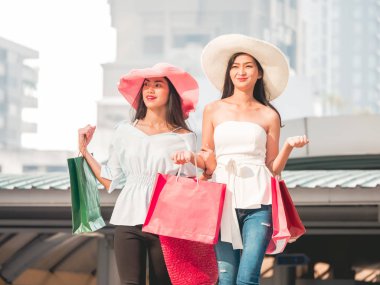 Alışveriş torbaları alışveriş zevk mutlu genç kadınlarla, Asyalı kız kendi alımları ile şehirde eğleniyorlar. Tüketicilik ve yaşam tarzı kavramı