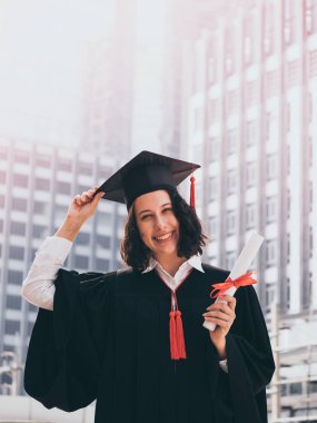Mezuniyet günü, mezuniyet kapağı ve cüppe holding diploma, başarılı konsepti olan kadın