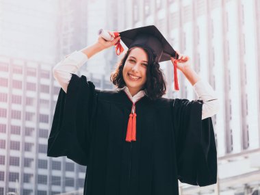 Mezuniyet günü, mezuniyet kapağı ve cüppe holding diploma, başarılı konsepti olan kadın