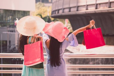 Arkadan Görünüm alışveriş torbaları alışveriş zevk olan genç kadın, iki kız şehirde kendi alımları ile eğlenceli yaşıyorsanız. Tüketicilik ve yaşam tarzı kavramı