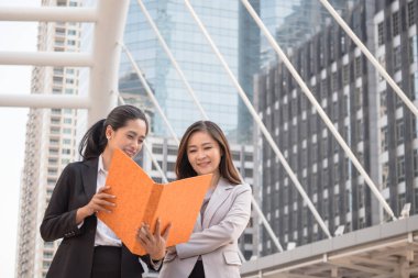 İş gözden geçirme iş kadını patronu ofis binası önünde dururken raporları.