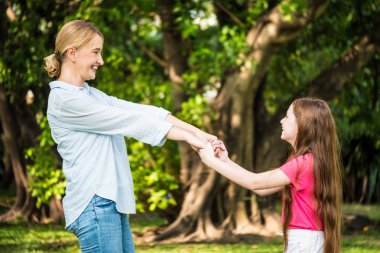 Anne ve kızı bir parkta birlikte eğleniyor. Aile ve yaşam tarzı kavramı