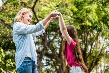 Anne ve kızı bir parkta birlikte eğleniyor. Aile ve yaşam tarzı kavramı