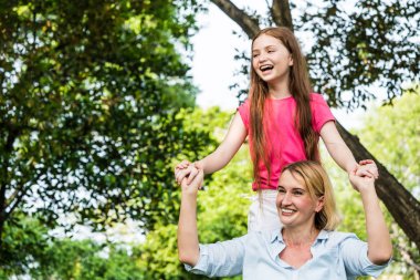 Anne ve kızı bir parkta birlikte eğleniyor. Aile ve yaşam tarzı kavramı