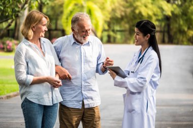 Yaşlı çift bir parkta Tıbbi Danışma söz doktorla. Sağlık kavramı