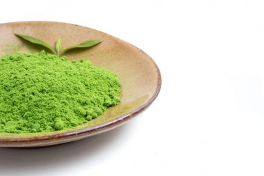 Seramik tabak beyaz zemin üzerine yeşil çay tozu.