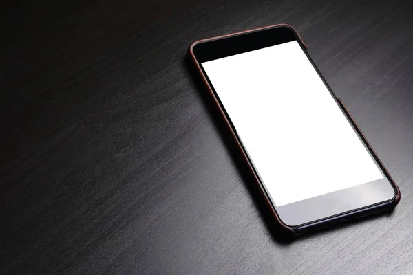 Чорний смартфон з білим екраном на темному фоні . — стокове фото