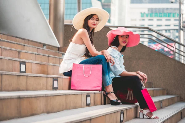 Mujeres jóvenes felices con bolsas de compras disfrutando en las compras, chicas asiáticas se están divirtiendo con sus compras en la ciudad. Concepto de consumo y estilo de vida — Foto de Stock