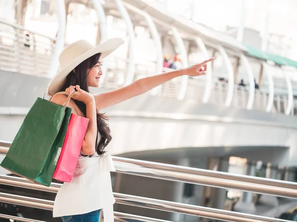 Mujer joven feliz con bolsas de compras disfrutando en las compras, chica asiática se divierte con sus compras en la ciudad. Concepto de consumo y estilo de vida —  Fotos de Stock