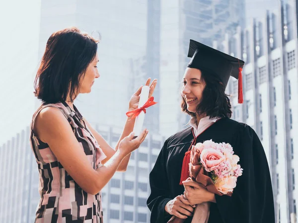 Vacker kvinna gratulerar för sin dotter på graduation dagen, framgångsrika koncept — Stockfoto