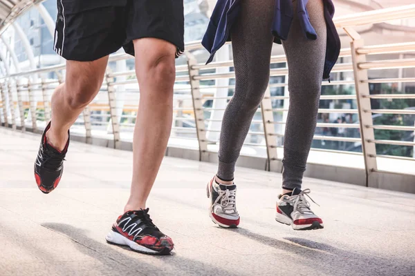 Close up of runners legs running on city bridge at the morning