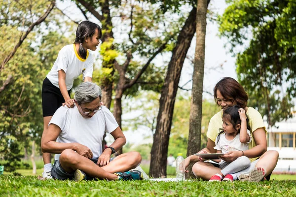 Atividades na família, Avô, mãe e filha relaxando no parque após o exercício — Fotografia de Stock