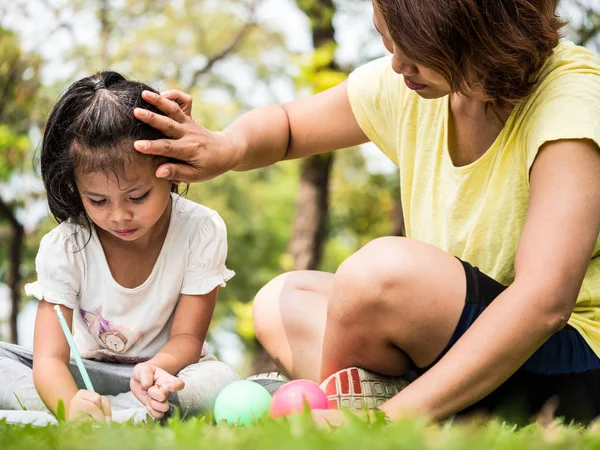 Close up da mãe ensinando filha para escrever em um parque — Fotografia de Stock